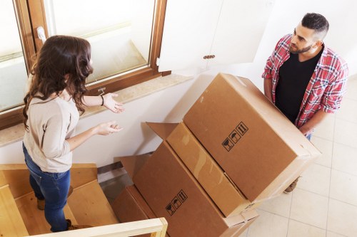 Removalists carrying furniture through a local property entrance